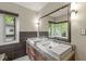 Bright bathroom featuring double sinks, granite counters, and a large decorative mirror with natural light at 518 Buckingham Dr, Indianapolis, IN 46208
