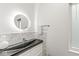 Contemporary bathroom features a vessel sink, a unique circular mirror, and stylish tile work at 518 Buckingham Dr, Indianapolis, IN 46208