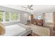 Bright bedroom featuring wood floors, a dresser, and large windows with outdoor views at 518 Buckingham Dr, Indianapolis, IN 46208