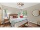 Cozy bedroom with hardwood floors, a comfortable bed, and a view of the neighborhood at 518 Buckingham Dr, Indianapolis, IN 46208