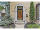 Close-up shot of the front door showcasing its unique design and stone frame with manicured shrubbery at 518 Buckingham Dr, Indianapolis, IN 46208