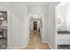 Hallway with hardwood floors leads to kitchen, bathroom, and front door at 518 Buckingham Dr, Indianapolis, IN 46208