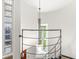 Modern staircase with metal railing, glass block windows, and a hanging light fixture at 518 Buckingham Dr, Indianapolis, IN 46208
