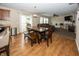 Dining area with wood flooring, a dining table set, and seamless access to the living room and kitchen at 5215 Climbing Rose Pl, Indianapolis, IN 46254