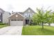 Charming two-story home with a brick and siding exterior, a well-manicured lawn, and an attached two-car garage at 5215 Climbing Rose Pl, Indianapolis, IN 46254