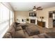Comfortable living room boasting a fireplace, a large sectional sofa, and windows that provide ample natural light at 5215 Climbing Rose Pl, Indianapolis, IN 46254