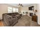 Bright living room showcasing a fireplace, a sectional sofa, and a ceiling fan for added comfort and style at 5215 Climbing Rose Pl, Indianapolis, IN 46254