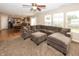 Spacious living room with a plush sectional sofa, a ceiling fan, and large windows that offer plenty of natural light at 5215 Climbing Rose Pl, Indianapolis, IN 46254