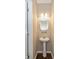Cozy half-bath features a pedestal sink, round mirror, decorative lighting, and wood-look flooring at 5767 Bluff View Ln, Whitestown, IN 46075
