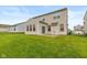 Rear exterior view of the house with a patio and spacious backyard with lawn at 5767 Bluff View Ln, Whitestown, IN 46075