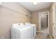 Functional laundry room with modern washer and dryer, shelving for storage, and ample room to move around in at 5767 Bluff View Ln, Whitestown, IN 46075