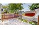 A backyard deck with a view of a gravel yard, neighboring houses, and mature trees at 615 Orange St, Indianapolis, IN 46203