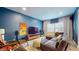 Stylish living room with a sectional sofa, TV, and unique artwork against a blue accent wall at 615 Orange St, Indianapolis, IN 46203