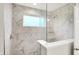 A bathroom shower with white marbled tile, a window, glass partition, and two shower heads at 6762 Brentwood Ct, Brownsburg, IN 46112