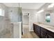 A bathroom featuring a dark vanity with double sinks, a shower, and tile flooring at 6762 Brentwood Ct, Brownsburg, IN 46112