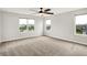 A bedroom with neutral carpet, white walls, three windows overlooking a lake, and a fan at 6762 Brentwood Ct, Brownsburg, IN 46112