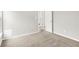 An empty bedroom with neutral carpet, white walls and trim and an open doorway at 6762 Brentwood Ct, Brownsburg, IN 46112