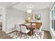 Open dining area with modern chandelier, hardwood floors, area rug and view of the front yard at 6762 Brentwood Ct, Brownsburg, IN 46112