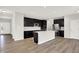 Spacious kitchen showcases a large island, dark cabinets, stainless steel appliances, and hardwood floors at 6762 Brentwood Ct, Brownsburg, IN 46112