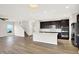 Modern, open kitchen features an island, dark cabinets, stainless steel appliances, and hardwood floors at 6762 Brentwood Ct, Brownsburg, IN 46112