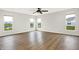 Living room with hardwood floors, recessed lighting and backyard views through three windows at 6762 Brentwood Ct, Brownsburg, IN 46112