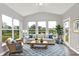 Bright sunroom features vaulted ceilings, large windows, comfortable seating, and views of the serene lake at 6762 Brentwood Ct, Brownsburg, IN 46112