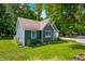 Quaint blue cottage with a side entrance, surrounded by lush greenery and a manicured lawn at 6933 Grey Wolf Dr, , IN 46164