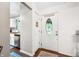 Bright foyer with decorative front door, white trim, and hardwood floors leads to a well-lit kitchen space at 6933 Grey Wolf Dr, , IN 46164