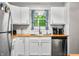 Charming kitchen features bright white cabinets, butcher block countertops, and stainless steel appliances with ample natural light at 6933 Grey Wolf Dr, , IN 46164