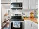 Well-lit kitchen featuring modern stainless steel appliances, subway tile backsplash, and butcher block countertops at 6933 Grey Wolf Dr, , IN 46164