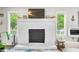A whitewashed fireplace with modern mantle sits between two windows allowing ample natural light at 6933 Grey Wolf Dr, , IN 46164