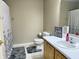 Well-lit bathroom with a single sink vanity, toilet, and shower with patterned curtain at 7042 Gavin Dr, Indianapolis, IN 46217