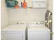 Functional laundry room featuring side-by-side washer and dryer units and upper shelf storage at 7042 Gavin Dr, Indianapolis, IN 46217