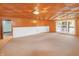 Basement with paneled walls, carpet, drop ceiling, storage, and door to the outside at 7061 Maryann Ct, Indianapolis, IN 46227