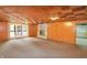 Basement living area with wood-look ceiling, fireplace, door to the outside, and storage area at 7061 Maryann Ct, Indianapolis, IN 46227
