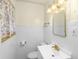 Bathroom with white tiled walls, small vanity with gold faucet, mirror and decorative lighting at 7061 Maryann Ct, Indianapolis, IN 46227
