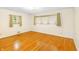 A bedroom with gleaming hardwood floors and natural light from two windows at 7061 Maryann Ct, Indianapolis, IN 46227