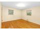 Bedroom with hardwood floors, two windows, and neutral wall color at 7061 Maryann Ct, Indianapolis, IN 46227