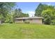 Single story home with a brick and stone facade, surrounded by a green lawn and mature trees under a blue sky at 7061 Maryann Ct, Indianapolis, IN 46227