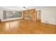 Spacious living room featuring hardwood floors, stone fireplace, and a large window offering a view of the yard at 7061 Maryann Ct, Indianapolis, IN 46227