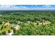 Expansive aerial view showcasing a private, wooded neighborhood with lush greenery and scattered residences at 7074 E Pine Needle Ln, Morgantown, IN 46160