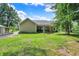 Home exterior with grassy backyard and tranquil surroundings, creating a peaceful outdoor retreat at 7074 E Pine Needle Ln, Morgantown, IN 46160