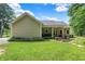 Spacious backyard featuring a covered patio, manicured lawn, and mature trees offering a serene outdoor retreat at 7074 E Pine Needle Ln, Morgantown, IN 46160