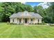 Charming home featuring a well-manicured lawn, lovely landscaping, and inviting front porch with classic rocking chairs at 7074 E Pine Needle Ln, Morgantown, IN 46160