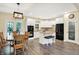 Modern kitchen with wooden dining set, white cabinets, wood flooring and black appliances at 7074 E Pine Needle Ln, Morgantown, IN 46160