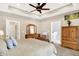 Spacious main bedroom featuring tray ceilings, ceiling fan, and wood furniture at 7074 E Pine Needle Ln, Morgantown, IN 46160