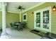 Inviting covered patio with a ceiling fan, outdoor lighting, and a dining set, perfect for relaxation and entertaining at 7074 E Pine Needle Ln, Morgantown, IN 46160