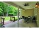 Covered patio with a fan, dining set, and overlooking a lush yard with mature trees at 7074 E Pine Needle Ln, Morgantown, IN 46160