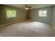 Spacious bedroom with neutral carpet, ceiling fan, and two windows offering natural light at 723 Bennett Rd, Carmel, IN 46032