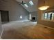 Open living room with vaulted ceiling, skylights, cozy fireplace, and plush carpeting at 723 Bennett Rd, Carmel, IN 46032